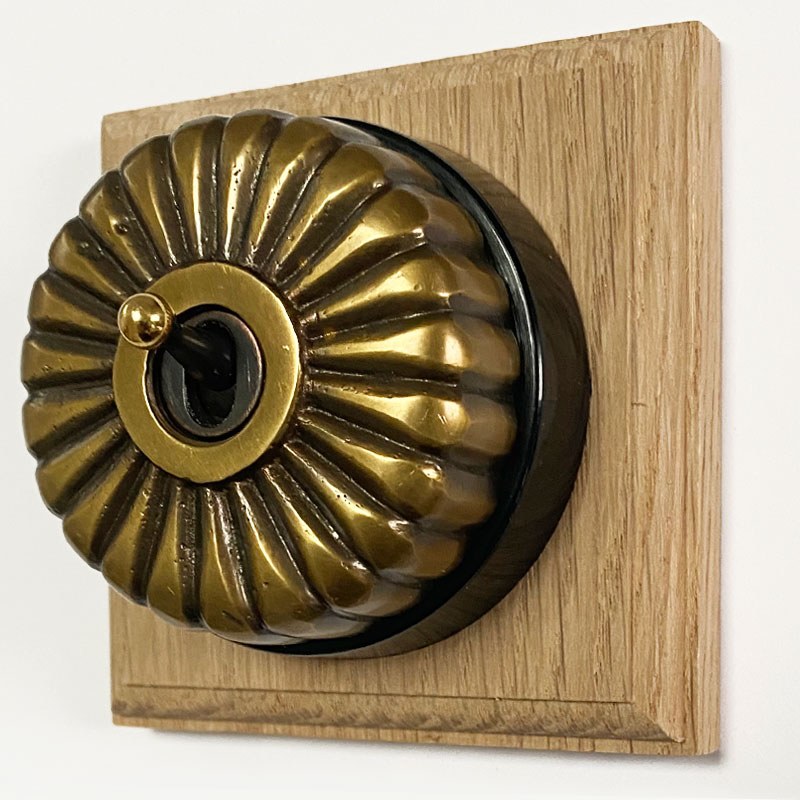 Fluted Round Dolly Light Switch Gang Antique Satin Brass Black Base  Broughtons Lighting  Ironmongery
