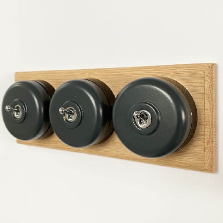 Round Dolly Light Switch 3 Gang Dark Grey on Oak Pattress with Black Mount