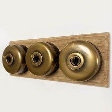 Round Dolly Light Switch 3 Gang on Oak Base Antique Satin Brass Black