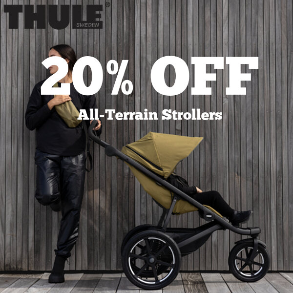 A picture of a women standing next to a Thule stroller with a child inside