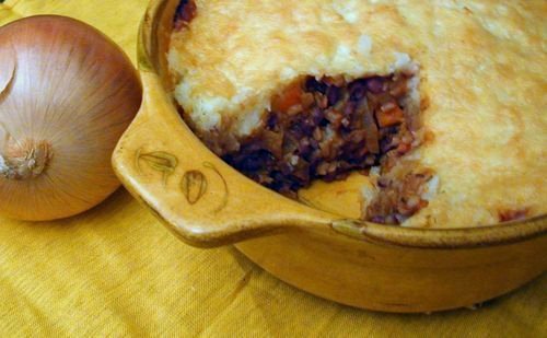 Red dragon pie in a casserole dish with a portion removed to show the finished recipe