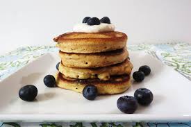 Stack of thick, fluffy pancakes topped with blueberries